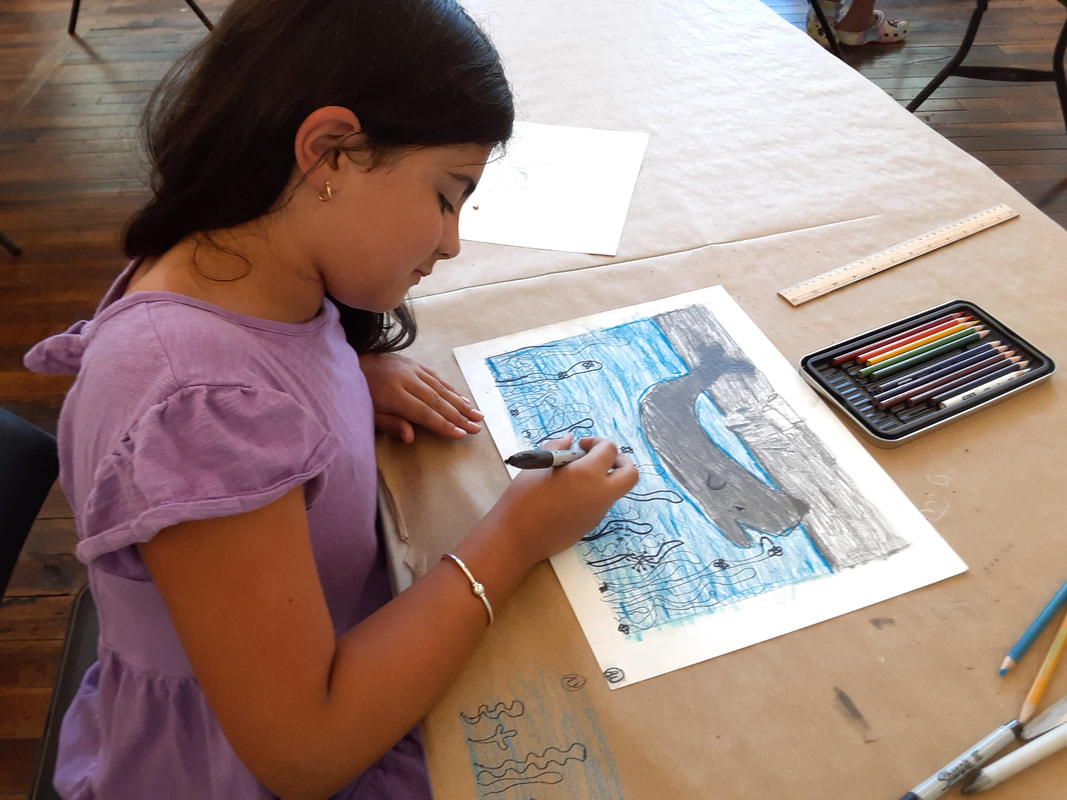 Child creating animal drawing using colored pencils and markers in an art class at an art school.