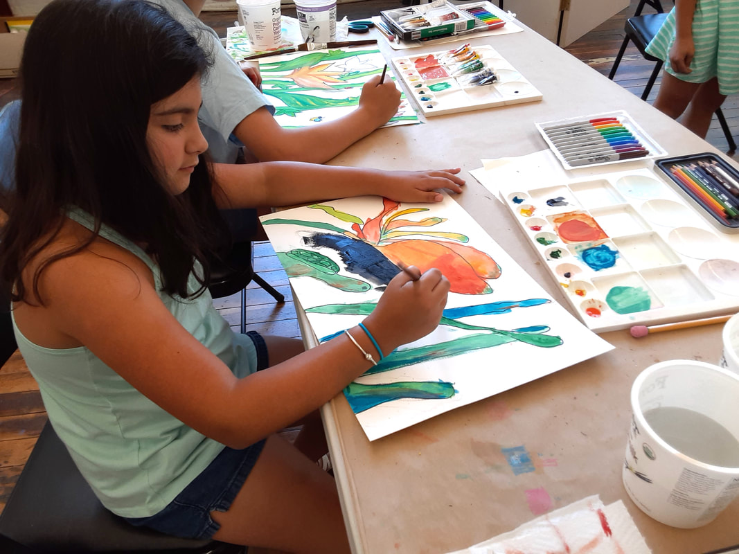 Student creating a watercolor painting in a children's art class during Summer Art Camp at Catherine Carter Art School in New Bedford.