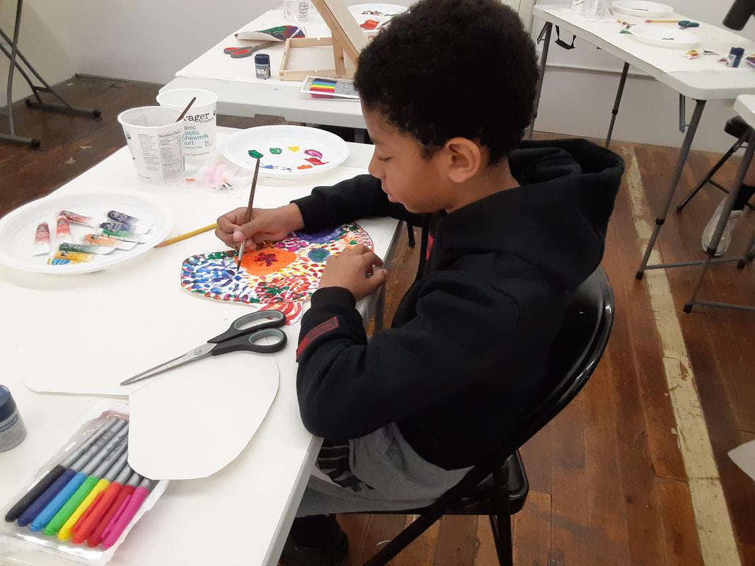 Child in art class creating a watercolor painting.