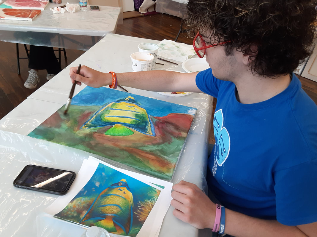 Teen creating an acrylic painting in an art class at an art school.